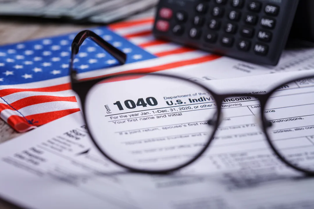 Trump tariffs 2025: Income tax with instruction, money, calculator and glasses. Tax payment and filing concept